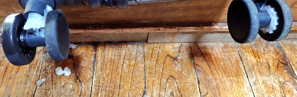 玄関でキャスターの雪水を落とす